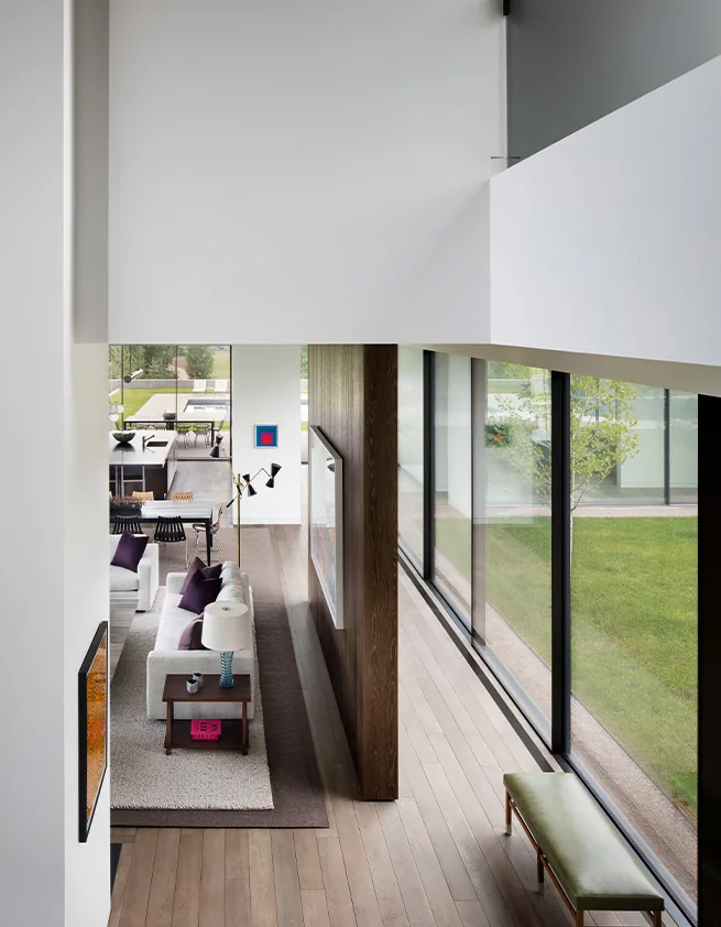 Mountain Modern project features a living area with large glass windows and a view of a green lawn.