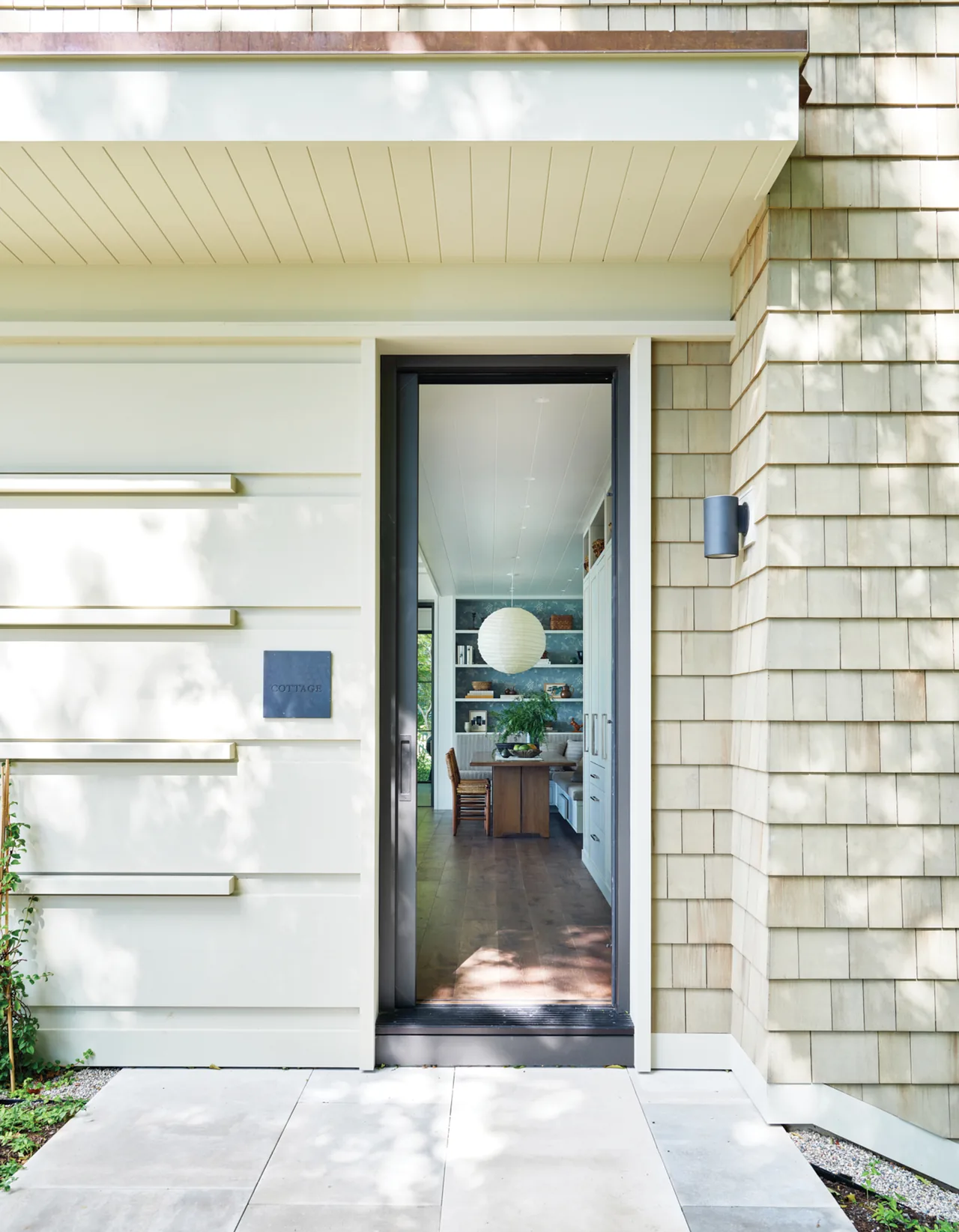 Exterior entrance with shingles and a glass door showing the interior dining space of the Making Waves project.