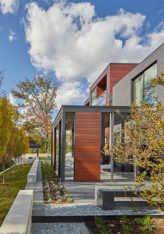 Exterior view of the Urban Woodland House featuring a mixed material facade of wood and brick.