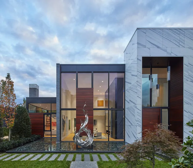 The Urban Woodland House features large glazed facades and white marble exterior walls with wood accents.