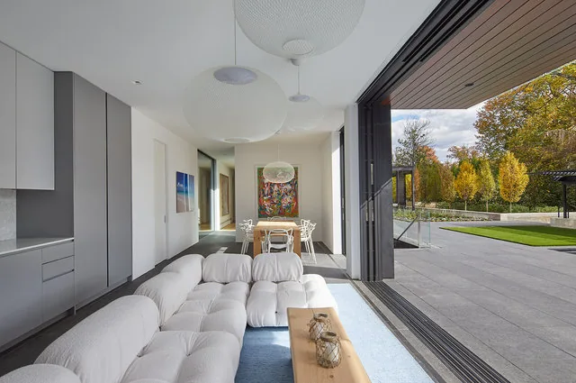 Living and dining space with seamless indoor-outdoor transition to patio and landscaped yard.