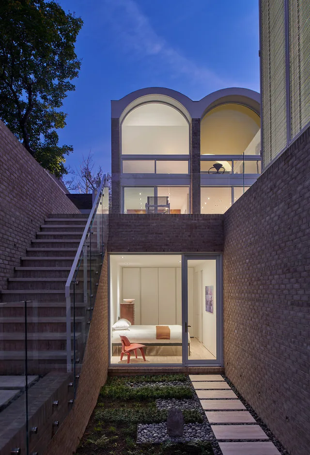 The Slayton House Renovation features vaulted arches and a sunken garden with a connecting staircase.
