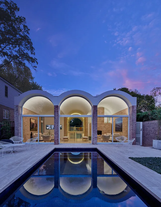 SLAYTON HOUSE RENOVATION AND ADDITION features barrel vault arches and a reflecting pool in the exterior rear courtyard.