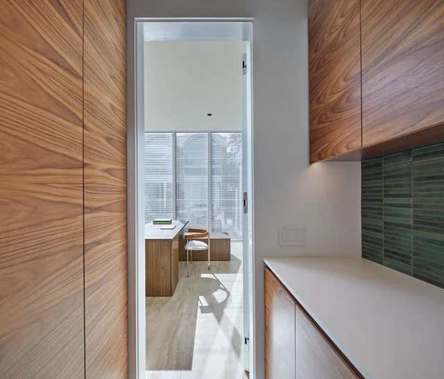 Modern renovation with wood cabinetry and a workspace illuminated by natural light through large windows.