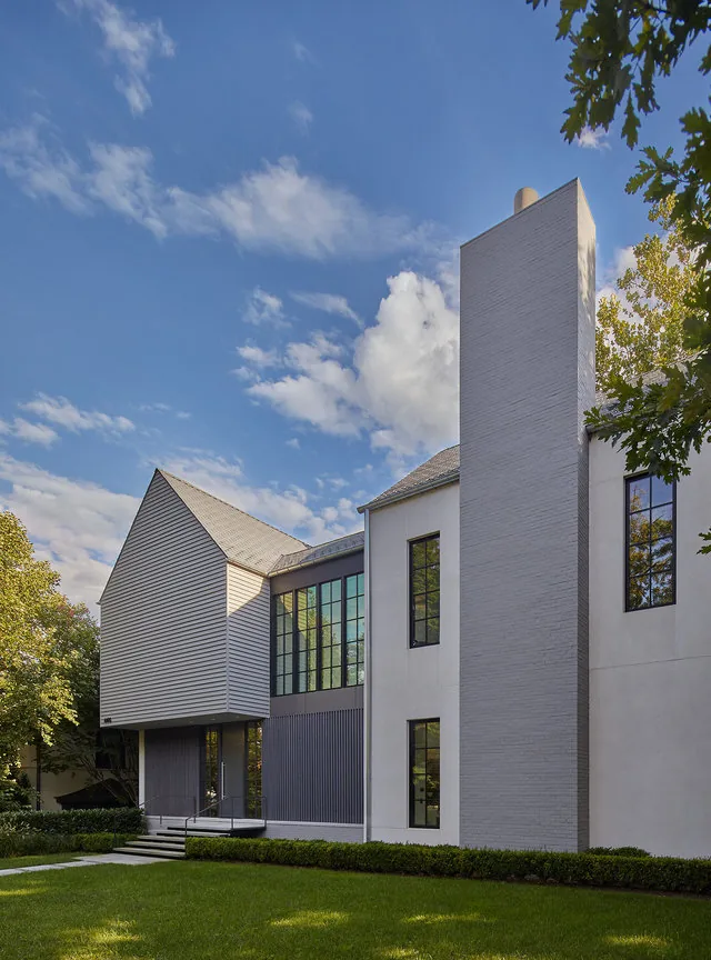 The Phillips Park House features a prominent central chimney, grid window pattern, and landscaped front yard.