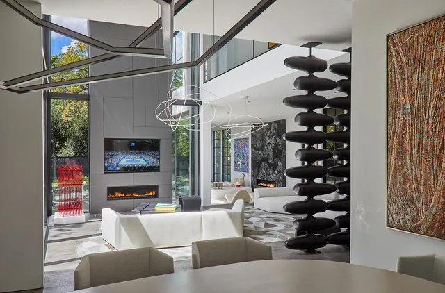 Interior of Phillips Park House features a double-height living area with a linear fireplace and contemporary art.