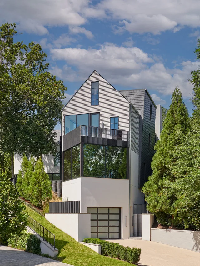 PHILLIPS PARK HOUSE by Robert Gurney Architects features a modern exterior with a black balcony railing and large glass windows.