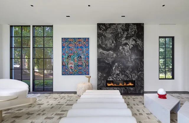 Living room featuring a central black marble fireplace and floor-to-ceiling windows with black grid frames.