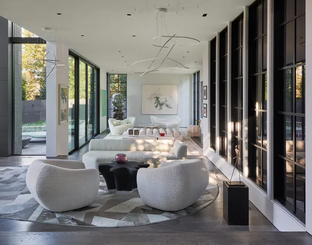 The PHILLIPS PARK HOUSE living room features curved plush seating, floor-to-ceiling glazing, and abstract wall art.