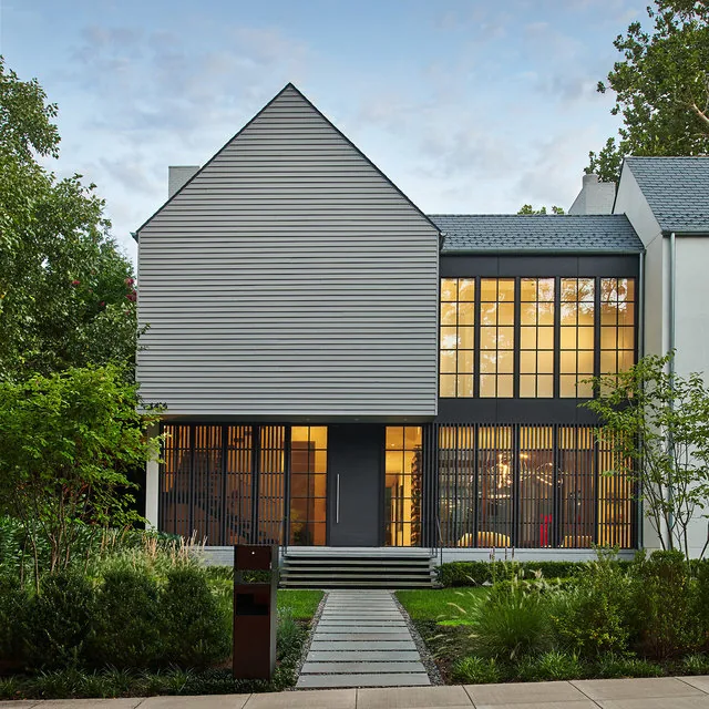 PHILLIPS PARK HOUSE by Robert Gurney Architects features a modern exterior with large grid windows and a landscaped pathway.