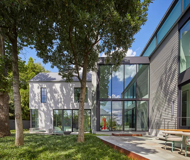 The Phillips Park House features floor-to-ceiling glazing and varied siding materials on its exterior façade.