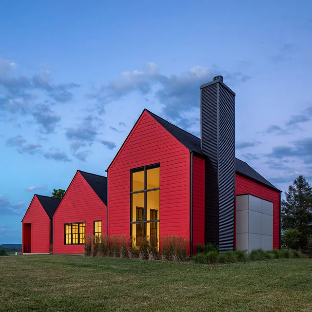 The ETLAN FARM HOUSE features a red exterior siding and three distinct gables, designed by Robert Gurney Architects.