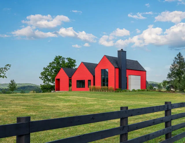 ETLAN FARM HOUSE features a red exterior siding with a black roof and chimney, set in a rural landscape with mountain views.