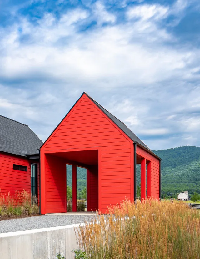 ETLAN FARM HOUSE features a red exterior with a gable roof and open passageway, set in a rural landscape with mountain views.