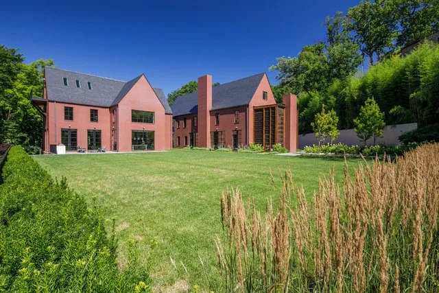 The 30TH STREET HOUSE features symmetrical brick construction with steep gable roofs and tall chimney set in a landscaped yard.