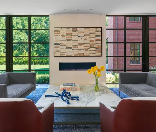 30TH STREET HOUSE living room features floor-to-ceiling black window frames and a minimalist rectangular fireplace.