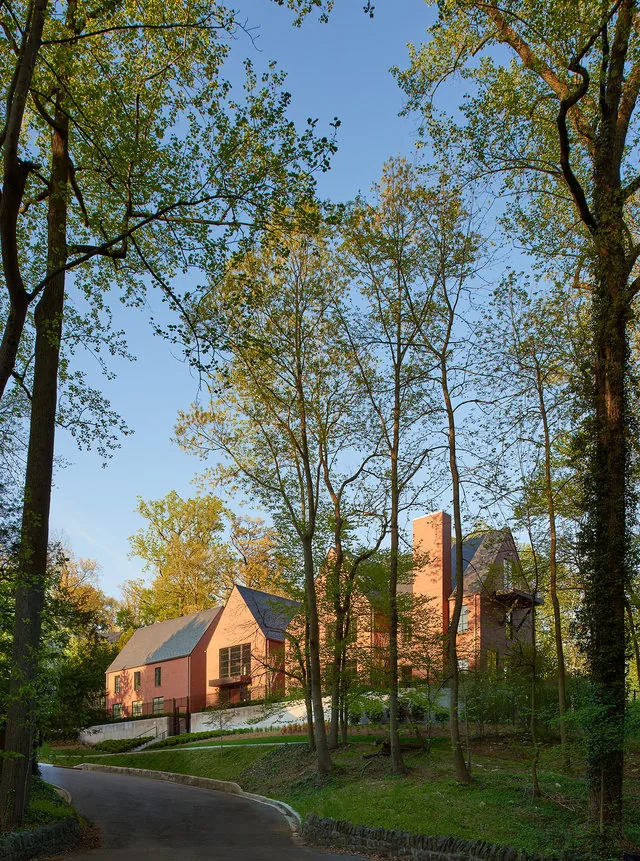 The 30TH STREET HOUSE features a brick exterior with steep gable roofs set amidst a wooded landscape.