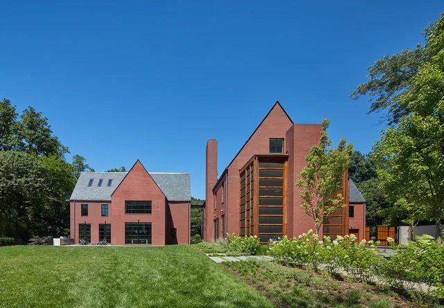 The 30TH STREET HOUSE features symmetrical red brick buildings with steep gable roofs and large windows that frame a landscaped garden and lawn.