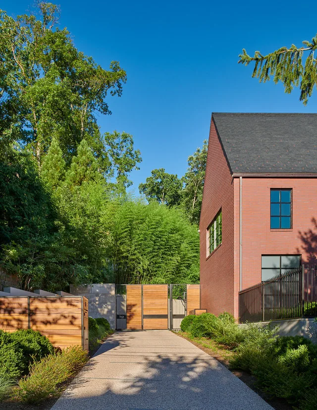 30TH STREET HOUSE features a steep gable roof and brick exterior with iron fencing and landscaped garden.