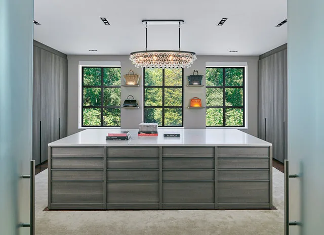 Spacious walk-in closet in 30TH STREET HOUSE with built-in storage, central island, and large windows for natural light.