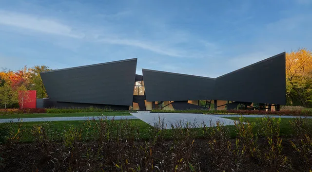 PTR HOUSE features angular black facade panels and prominent triangular windows, designed by Robert Gurney Architects.