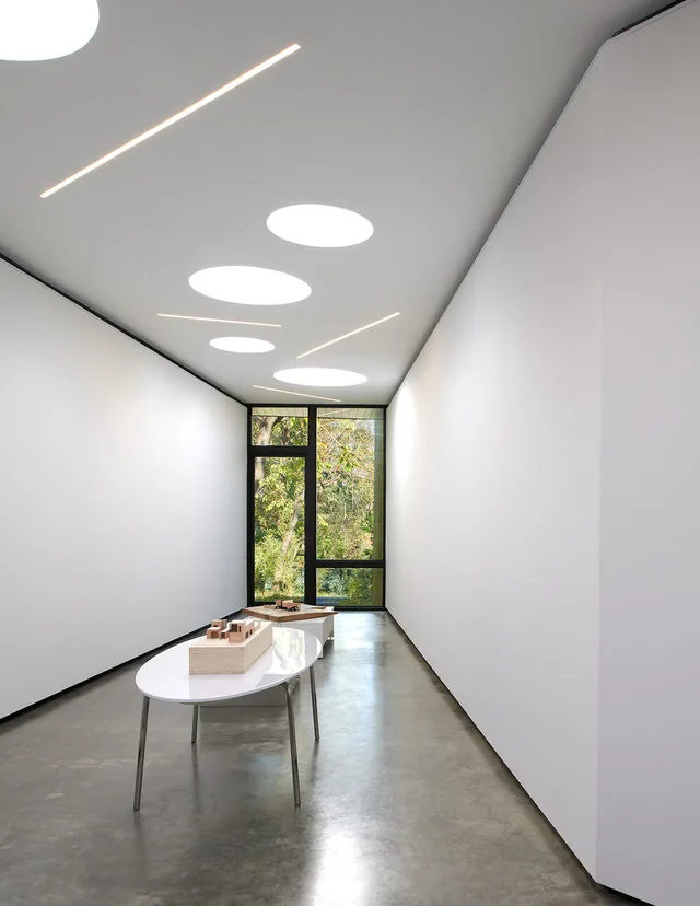 Interior hallway with polished concrete flooring and circular recessed lights in the ceiling.
