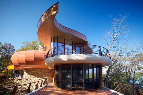 Chenequa Residence features a curved wood ceiling, stone chimney, and rounded balcony detail.