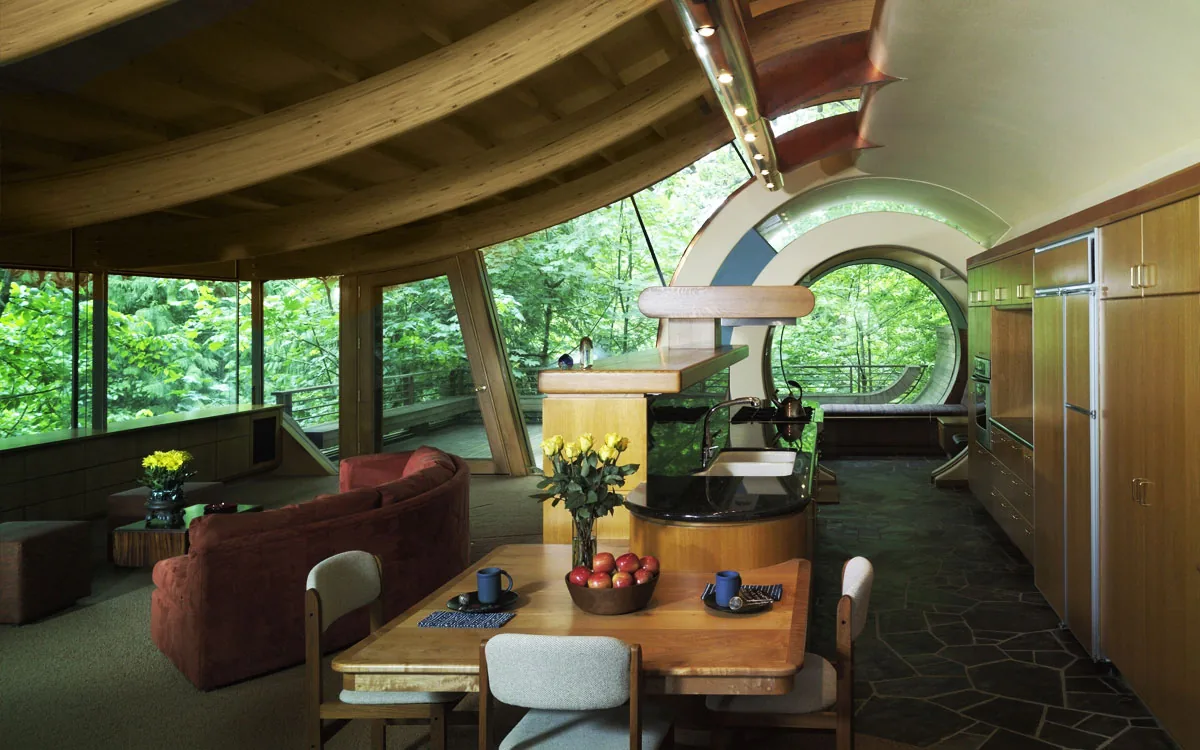 Wilkinson Residence interior with curved wood ceiling, circular window, and integrated living and kitchen space by Robert Harvey Oshatz.