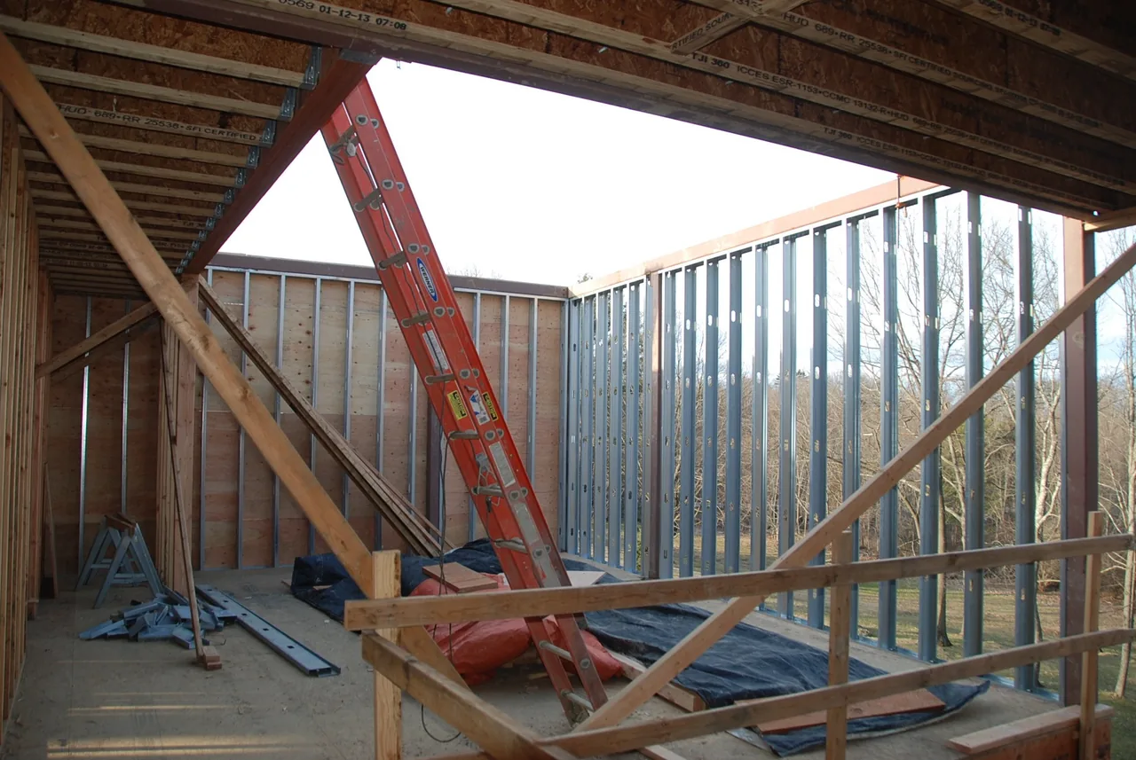 Second floor framing with wood joists and metal exterior wall studs in mid-construction.