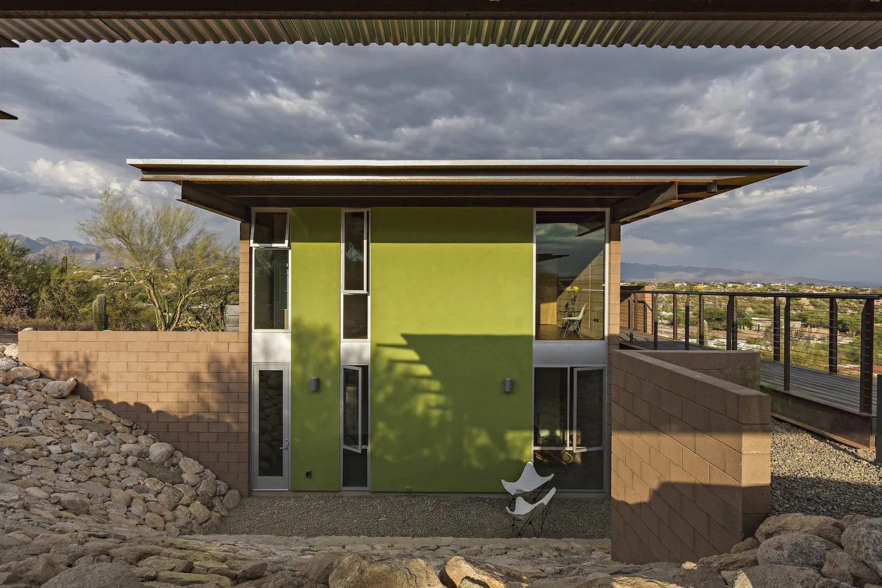 DWC House with a flat roof and green stucco exterior in a desert setting near Phoenix.