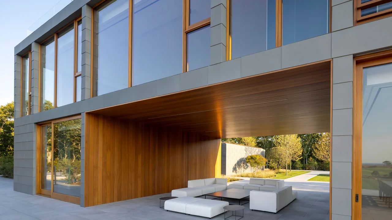 Fairway House exterior showing wood-paneled recessed outdoor seating and large floor-to-ceiling windows framed in wood.
