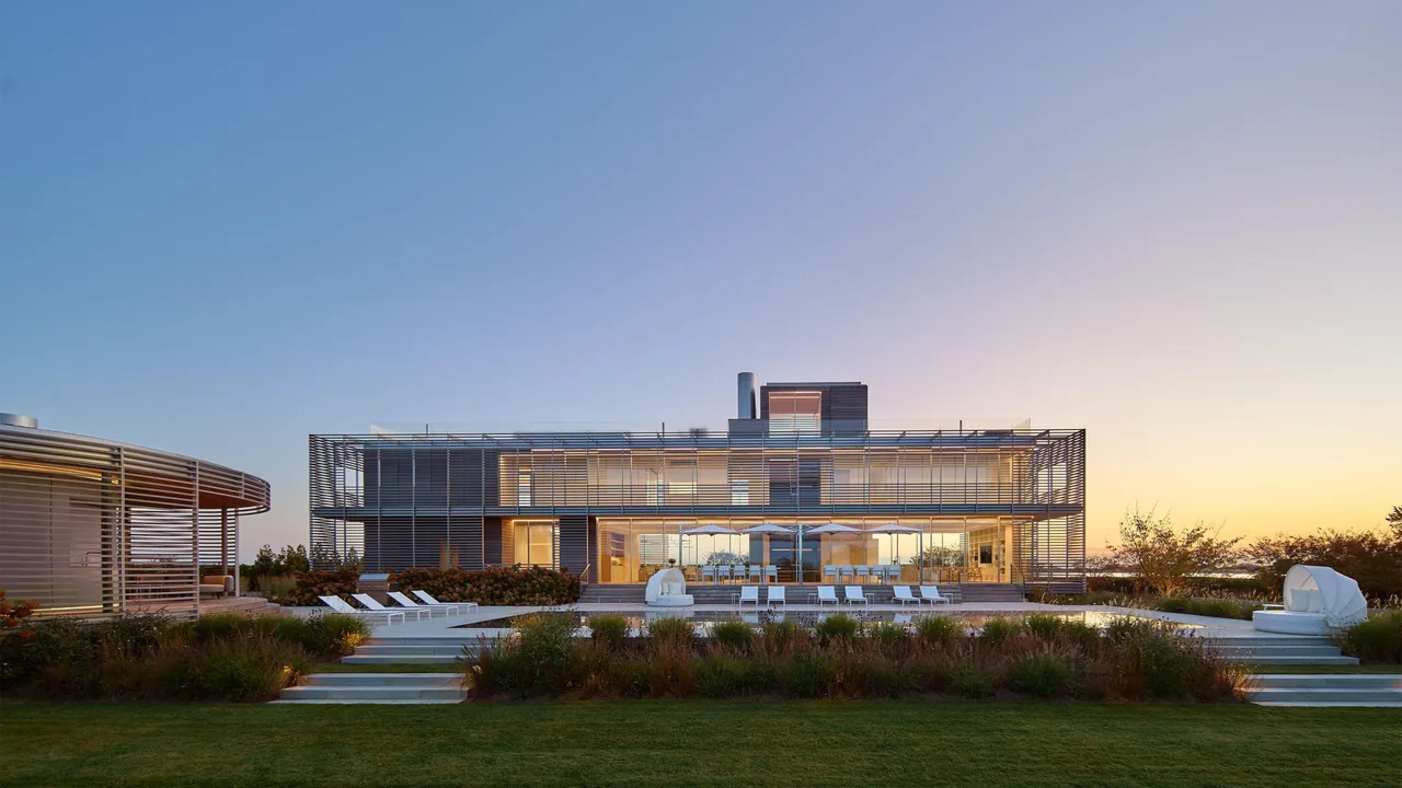 Porch House features horizontal wooden slat screens over large windows on a two-story design with outdoor lounge furniture by a pool.