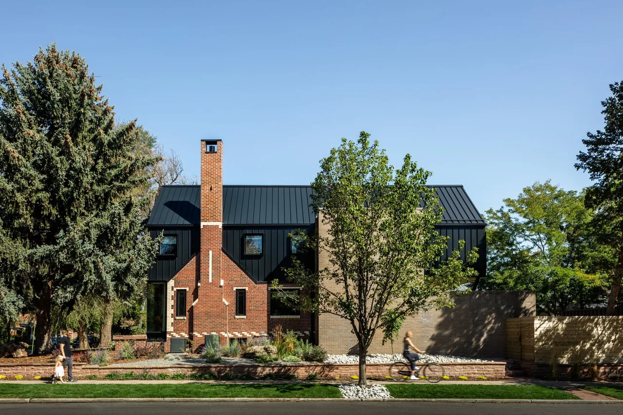 Rabbit House designed by Roth Sheppard Architects features a steep standing seam metal roof with brick and stone exterior finishes.
