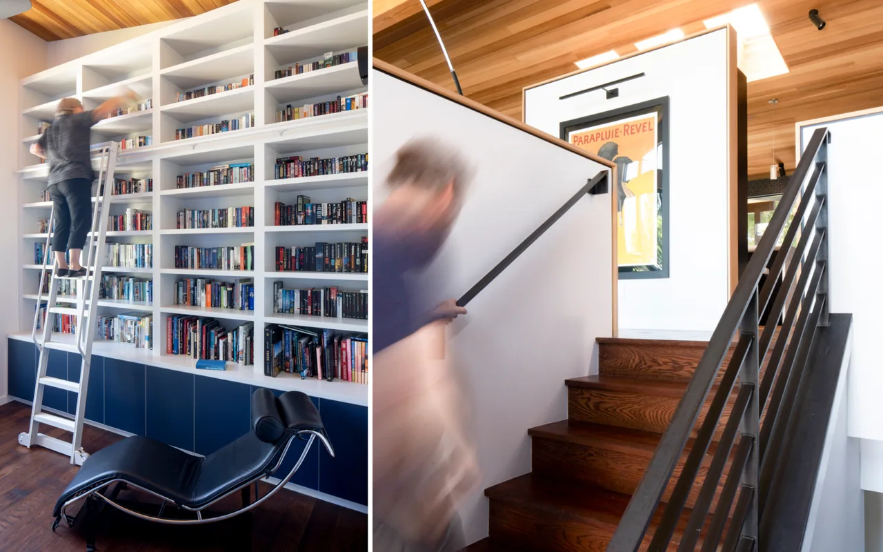 Interior view showing a built-in white bookshelf with blue lower cabinets and an adjacent staircase with black metal railing and wooden steps.