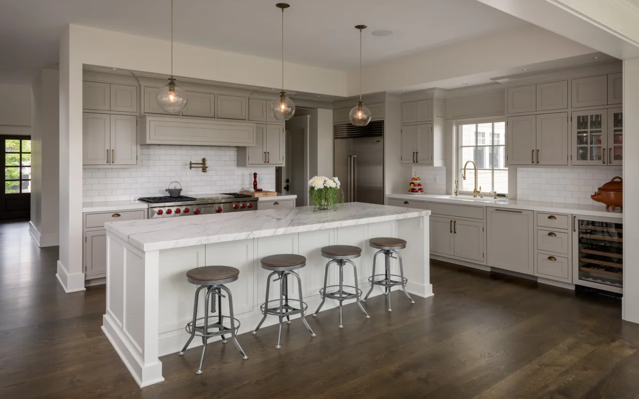 Kitchen featuring a large marble island, white cabinets, subway tile backsplash, and stainless steel appliances.