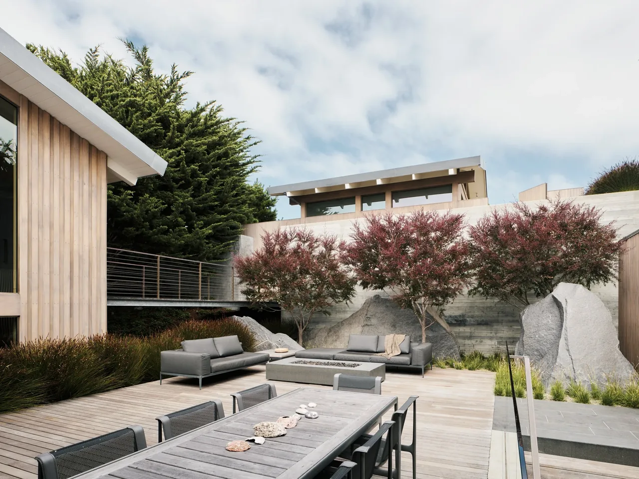 The Carmel project features an outdoor patio with wood decking and gray seating by Sagan Piechota Architecture.