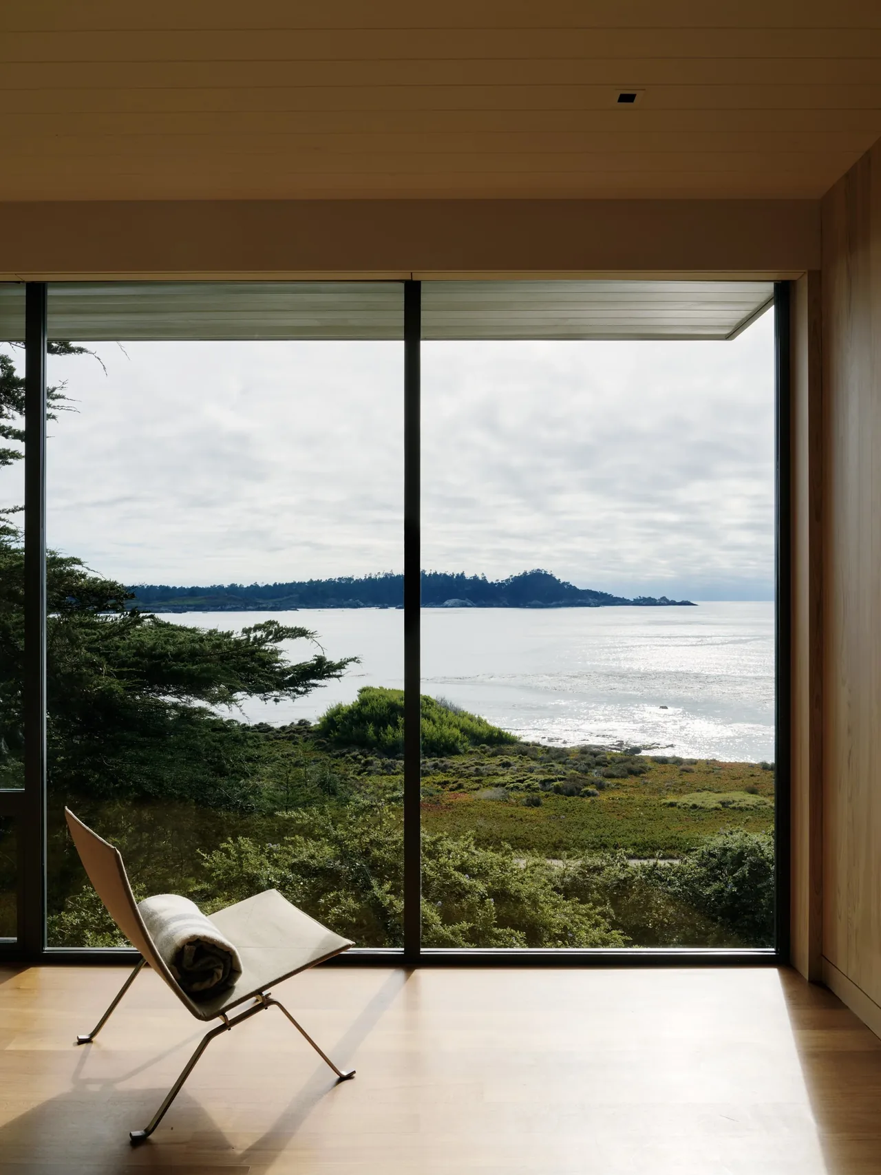 Living space with floor-to-ceiling sliding glass doors providing expansive ocean views in the Carmel project.