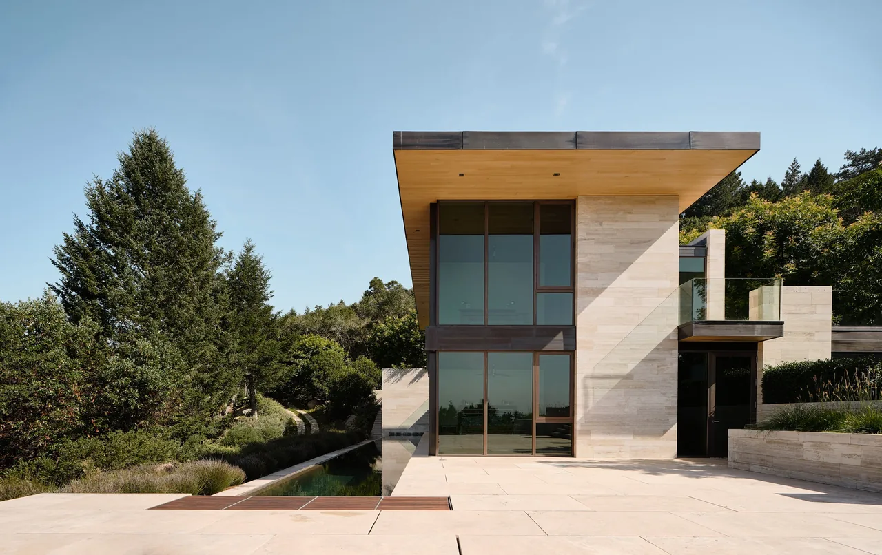 Exterior view of St Helena, a modern house with large glass windows and wood soffit by Sagan Piechota Architecture.