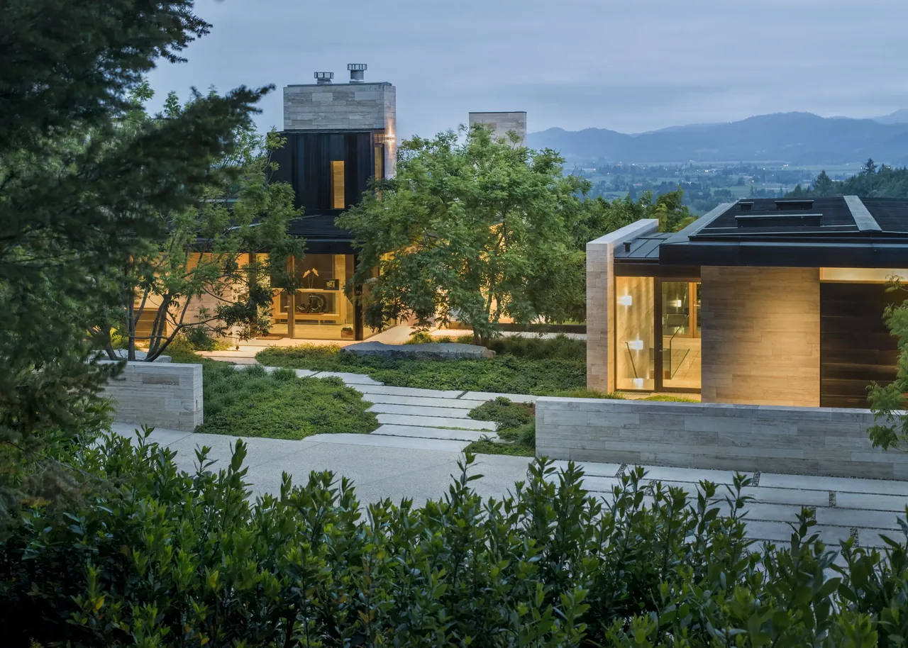 St Helena project by Sagan Piechota Architecture features stone walls and extensive landscaping with a stepped stone path.