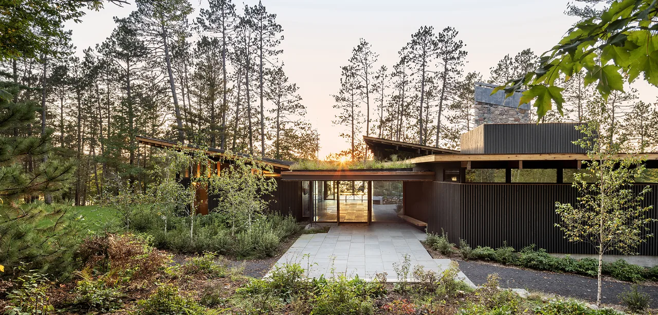 Exterior front view of The Nest by SALA Architects featuring vertical siding and green roof elements.