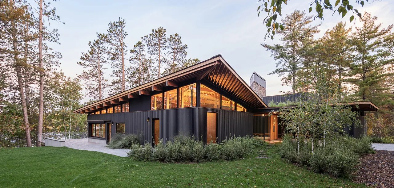 The Nest by SALA Architects features a dark corrugated exterior and dramatic angled roof.