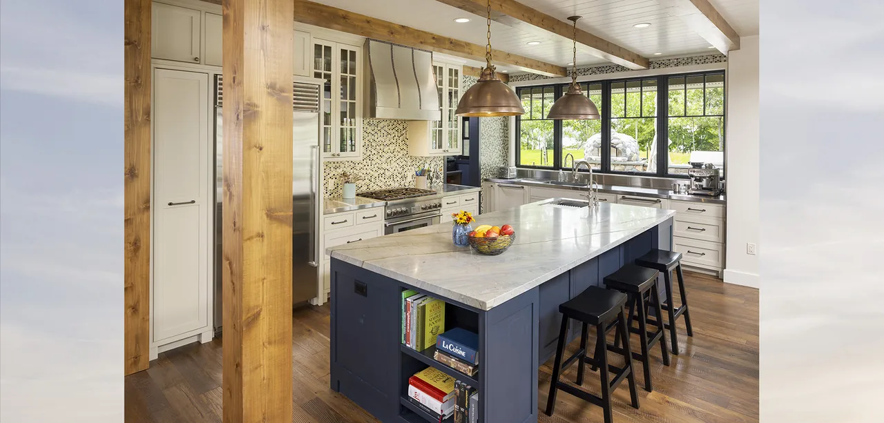 Tall Tree Lodge kitchen features a marble island with built-in bookshelf and pendant lights above.