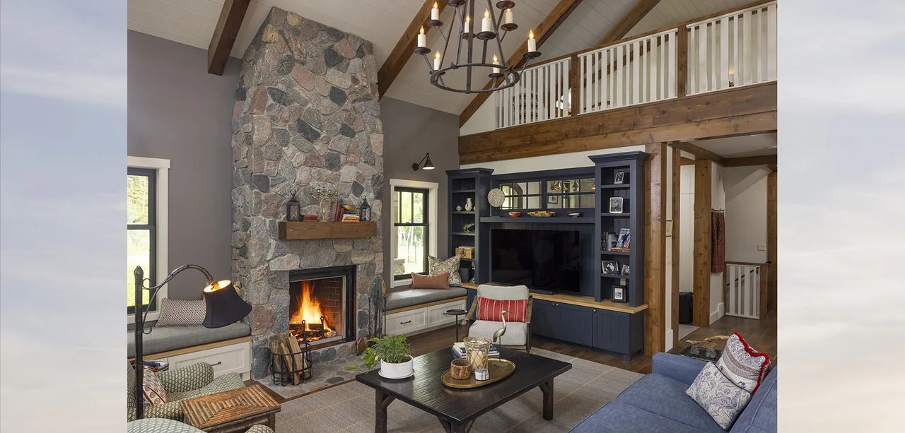 Living room of Tall Tree Lodge with vaulted ceiling, stone fireplace, built-in shelving, and exposed wood beams.