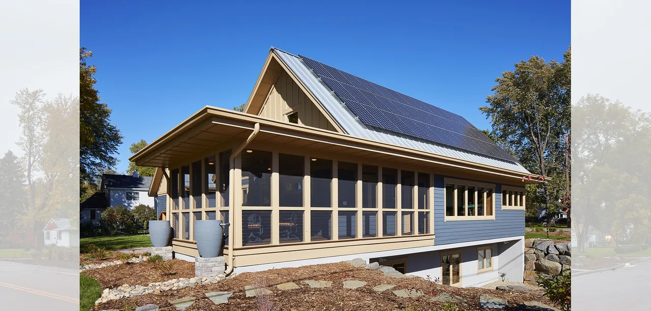 Gable roof house with a screened porch and solar panels on the standing seam metal roof.