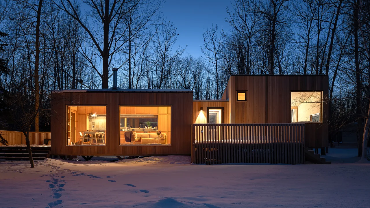 Warroad CLT House features large picture windows and wood panel exterior in a snowy landscape.