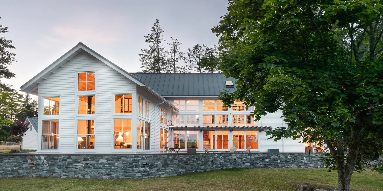 Exterior rear view of MAP CORNER house with extensive floor-to-ceiling windows and a metal roof by Stoltz Kau Architects.