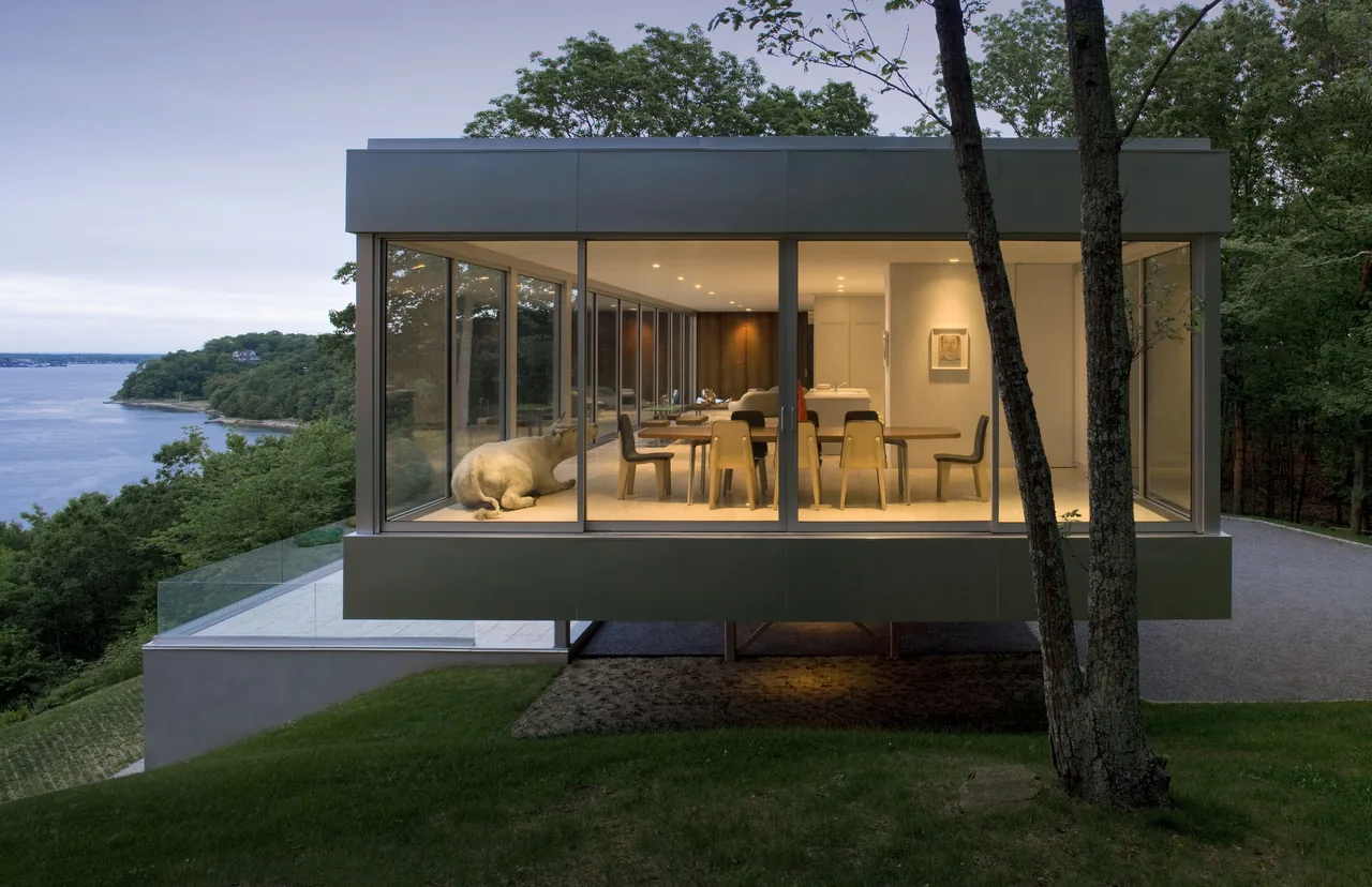 Clearhouse features an elevated design with floor-to-ceiling glazing and a dining area surrounded by glass walls.
