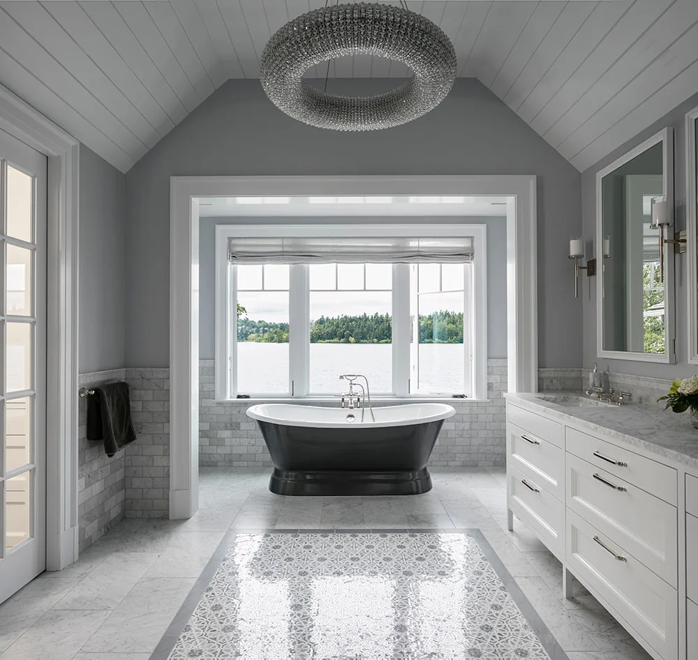 Bathroom features a black freestanding tub, white marble floor with patterned inlay, and gray walls with white trim.