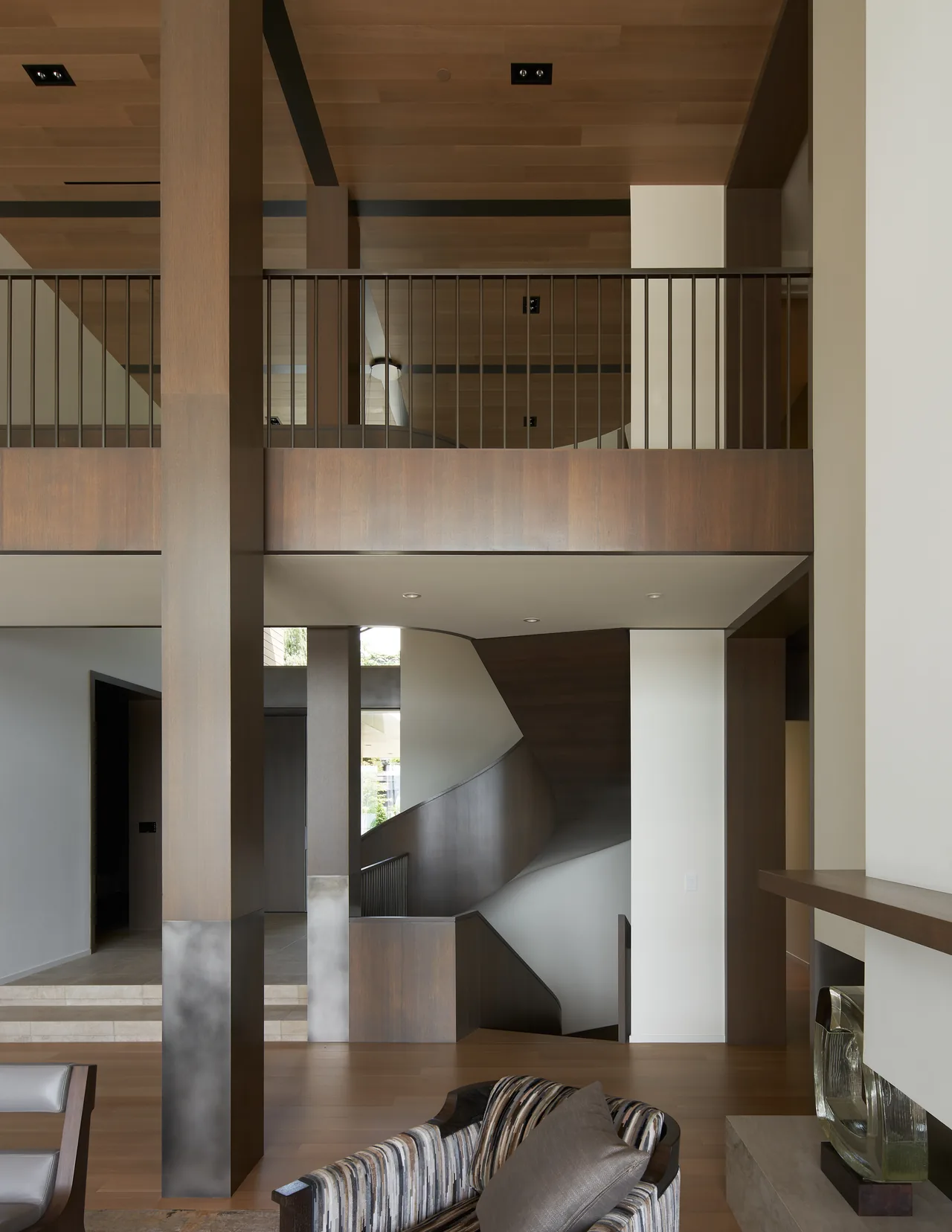 Union Bay Residence features a two-story interior with wood ceiling, curved staircase, and open railing design.