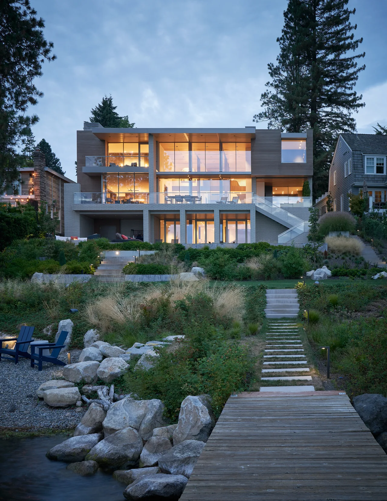 Union Bay Residence features extensive floor-to-ceiling glazing and a multi-level outdoor stair connecting balconies to lakeside access.